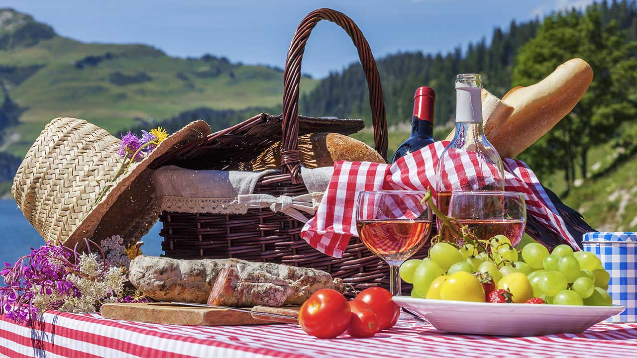 Picnic setup plates, napkins, and baskets on a blanket
